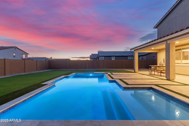 pool at dusk featuring a patio area, a fenced in pool, and a fenced backyard