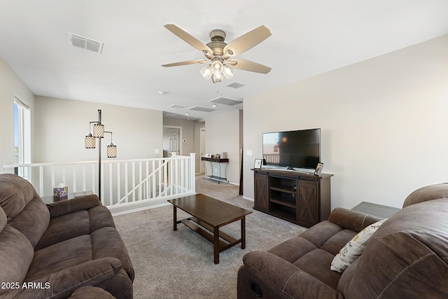 living area featuring light carpet, visible vents, and a ceiling fan