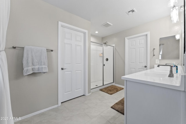 bathroom featuring vanity, baseboards, visible vents, and a stall shower