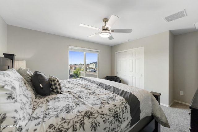 carpeted bedroom featuring a ceiling fan, visible vents, a closet, and baseboards