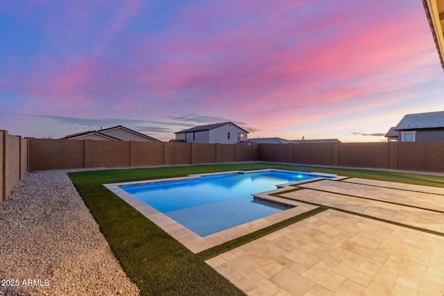 pool at dusk with a patio area, a fenced in pool, a yard, and a fenced backyard