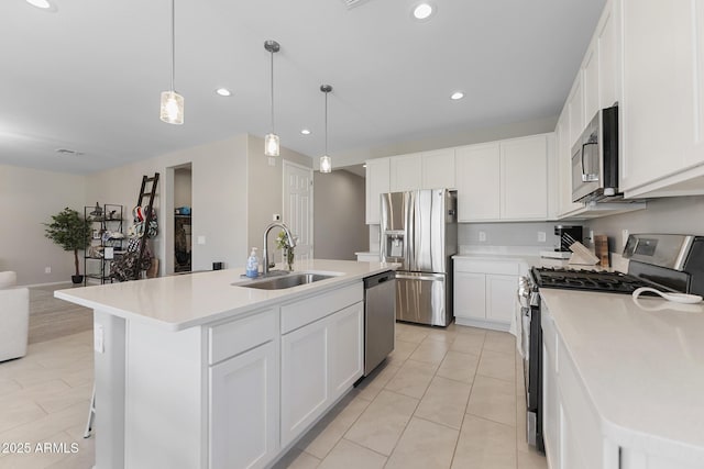 kitchen with light countertops, recessed lighting, white cabinets, stainless steel appliances, and a sink