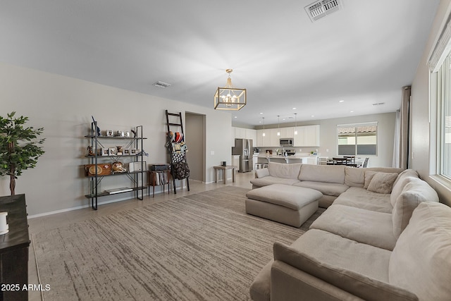 living area with an inviting chandelier, recessed lighting, visible vents, and baseboards