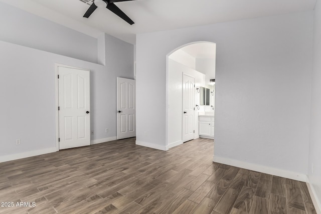 2015 E Glenhaven Dr, Phoenix, AZ 85048 - spare room featuring lofted ceiling, ceiling fan, wood finished floors, baseboards, and arched walkways