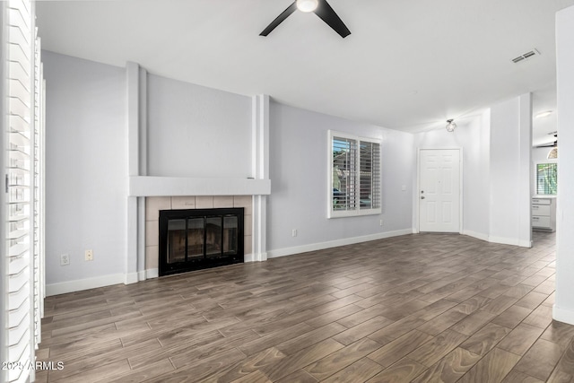 2015 E Glenhaven Dr, Phoenix, AZ 85048 - unfurnished living room with a ceiling fan, wood finished floors, a fireplace, and baseboards