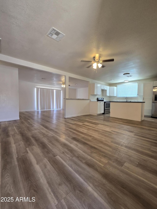 4911 W Merrell St, Phoenix, AZ 85031 - unfurnished living room featuring dark wood-type flooring, ceiling fan, and a textured ceiling
