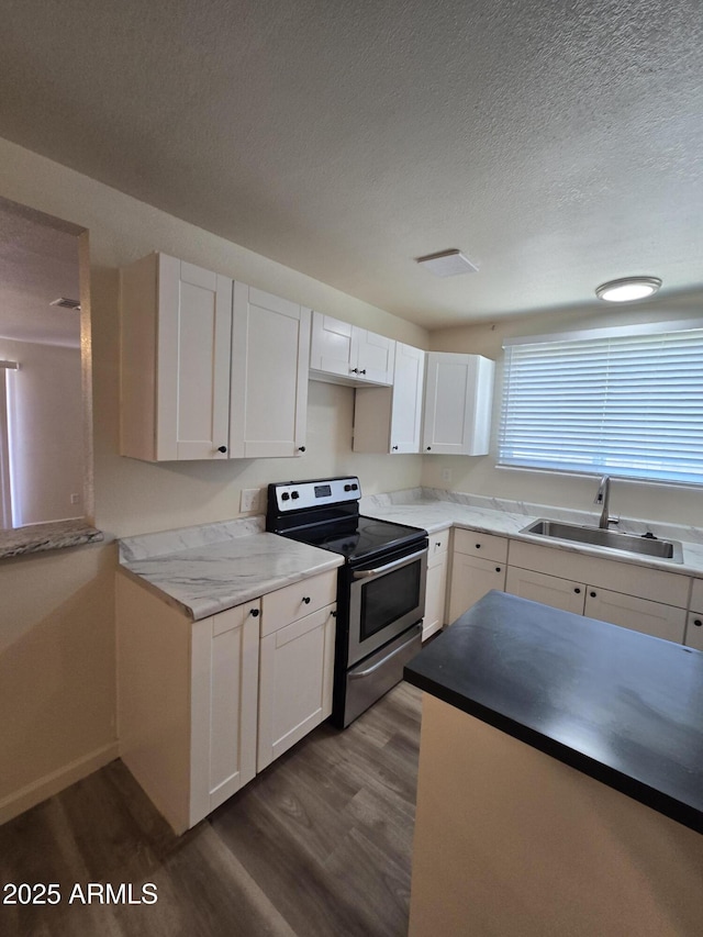 4911 W Merrell St, Phoenix, AZ 85031 - kitchen with stainless steel electric stove, dark wood-style floors, a textured ceiling, and white cabinetry