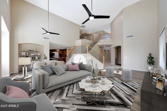5726 W Park View Ln, Glendale, AZ 85310 - living area with ceiling fan, a towering ceiling, stairs, arched walkways, and wood finished floors