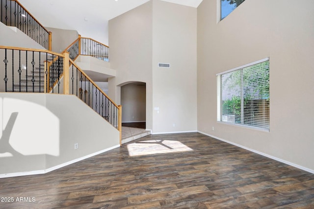 5726 W Park View Ln, Glendale, AZ 85310 - foyer featuring arched walkways, a towering ceiling, wood finished floors, stairway, and baseboards