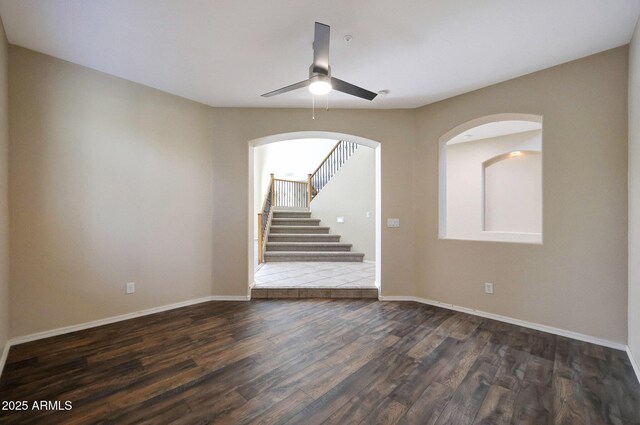 5726 W Park View Ln, Glendale, AZ 85310 - empty room featuring dark wood-style flooring, a ceiling fan, stairs, and baseboards