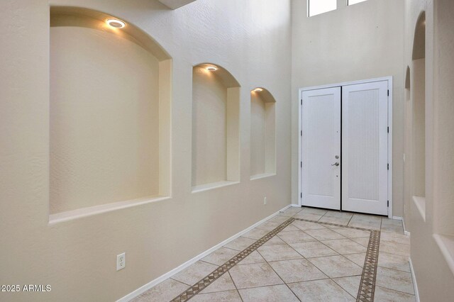 5726 W Park View Ln, Glendale, AZ 85310 - entrance foyer featuring baseboards, a high ceiling, arched walkways, light tile patterned floors, and inlaid floor details
