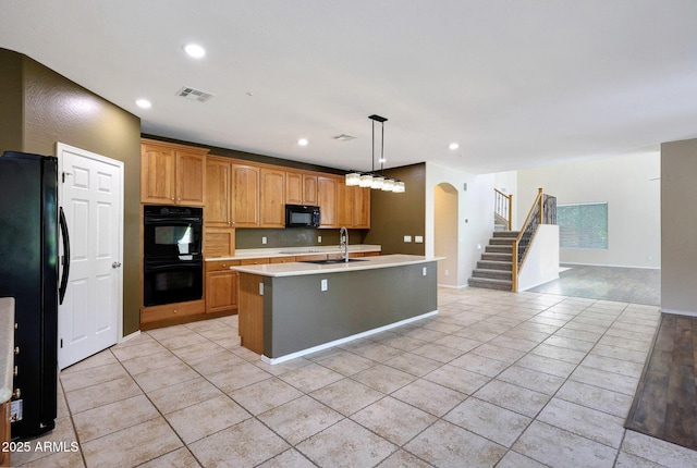 5726 W Park View Ln, Glendale, AZ 85310 - kitchen featuring black appliances, light countertops, a center island with sink, light tile patterned flooring, and a sink