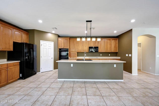 5726 W Park View Ln, Glendale, AZ 85310 - kitchen featuring black appliances, arched walkways, a kitchen island with sink, light countertops, and a sink