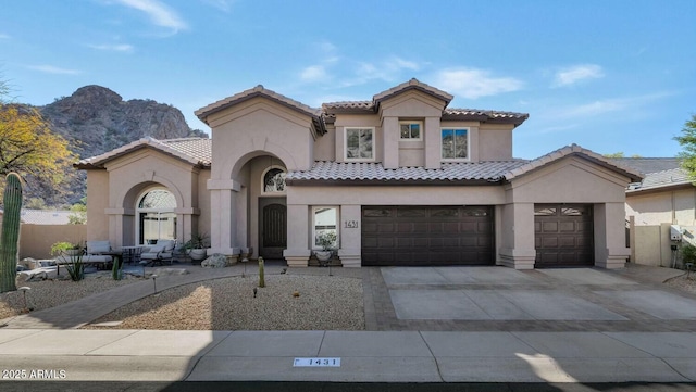 mediterranean / spanish home featuring a garage and a mountain view