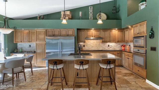 kitchen featuring pendant lighting, built in appliances, sink, a kitchen island with sink, and high vaulted ceiling