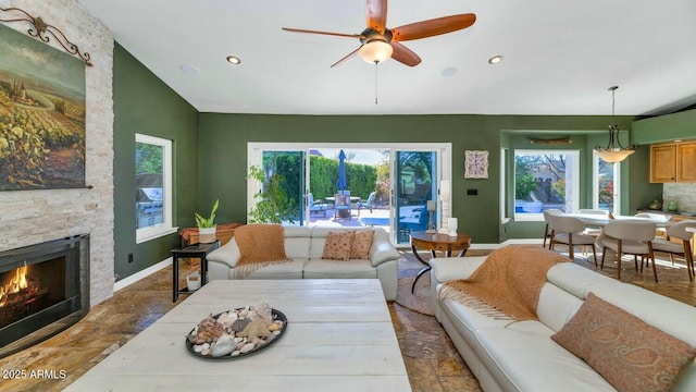 living room with ceiling fan and a fireplace