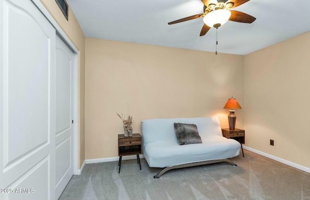 sitting room featuring light carpet and ceiling fan