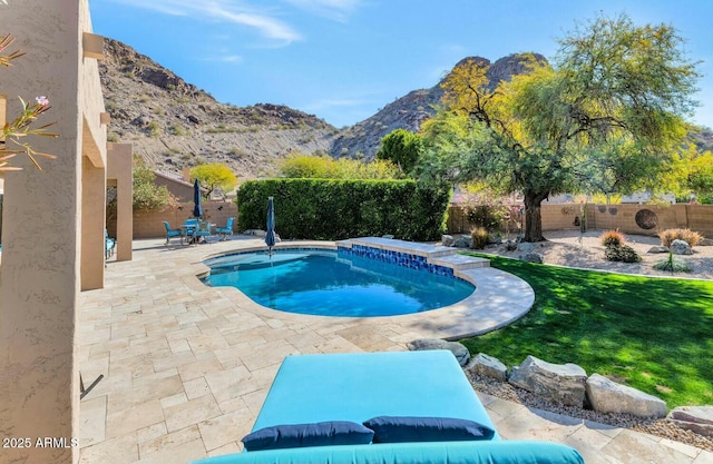 view of pool with a mountain view, a patio area, and a lawn