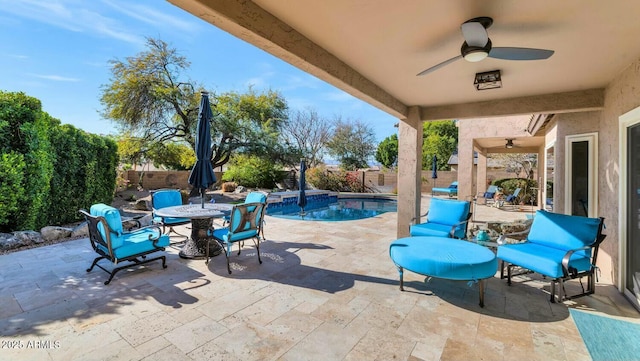 view of patio featuring ceiling fan and a fenced in pool