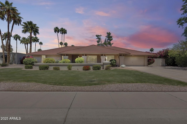 ranch-style house with an attached garage, driveway, a tile roof, stucco siding, and a front lawn