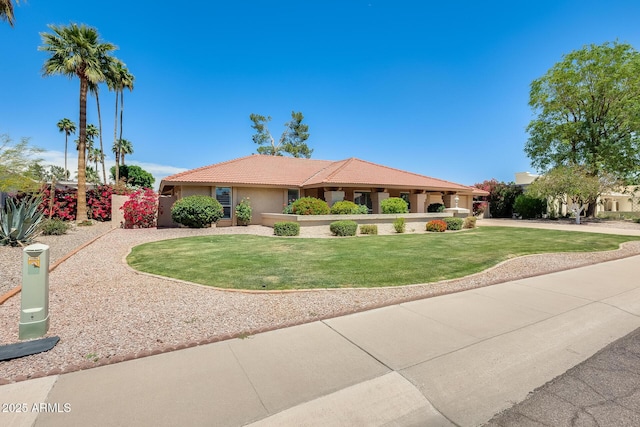 ranch-style home with a front lawn, stucco siding, and a tile roof