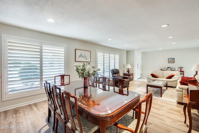 dining space featuring a textured ceiling, light wood-style floors, and recessed lighting
