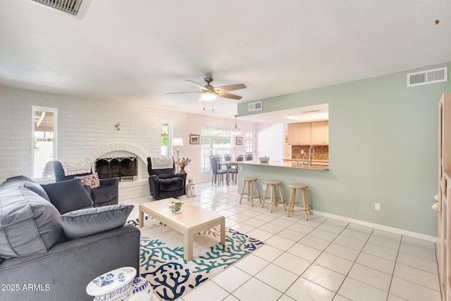 living area featuring ceiling fan, visible vents, and light tile patterned flooring
