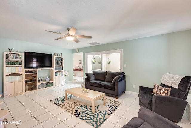 living room featuring light tile patterned floors, baseboards, a ceiling fan, and visible vents