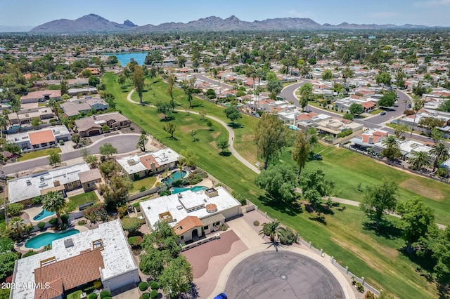 drone / aerial view featuring a mountain view, view of golf course, and a residential view