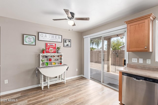 interior space with light wood-style floors, a ceiling fan, and baseboards
