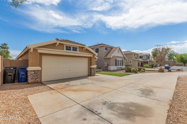 view of front of property with stucco siding, a garage, stone siding, driveway, and a residential view