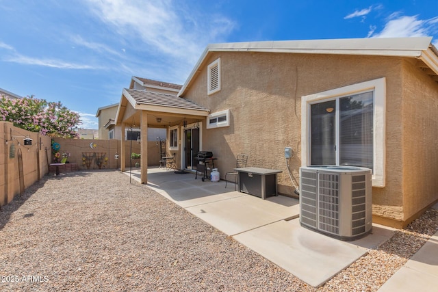 back of house featuring stucco siding, central air condition unit, a patio, and a fenced backyard