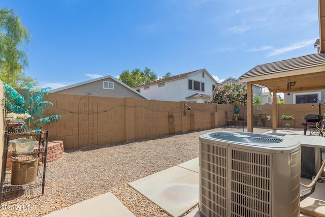fenced backyard featuring central air condition unit and a patio area