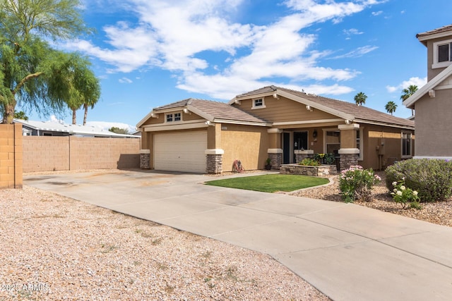 view of front of house featuring fence, stucco siding, stone siding, concrete driveway, and a tiled roof