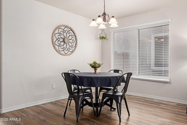 dining area with a chandelier, baseboards, and wood finished floors