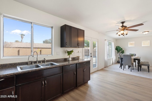 kitchen with sink, ceiling fan, dark brown cabinets, french doors, and light wood-type flooring