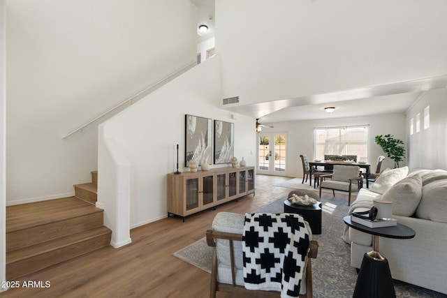 living room with wood-type flooring, french doors, and a high ceiling