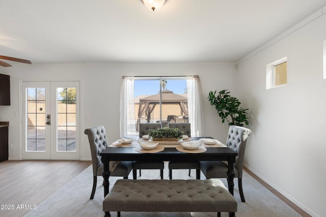 dining area featuring french doors, a healthy amount of sunlight, and light wood-type flooring