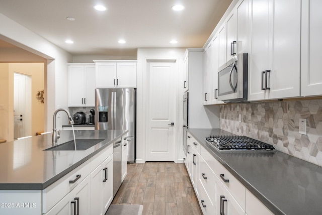 923 W Yellowstone Way, Chandler, AZ 85248 - kitchen featuring appliances with stainless steel finishes, dark countertops, recessed lighting, light wood-type flooring, and white cabinets