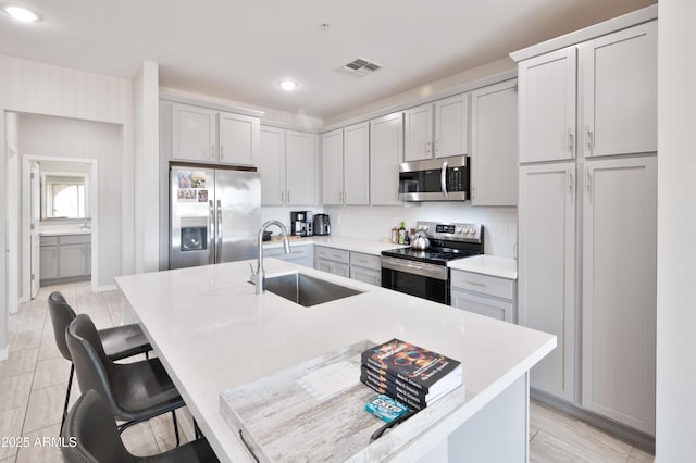 155 N Lakeview Blvd Unit 268, Chandler, AZ 85225 - kitchen with appliances with stainless steel finishes, a sink, an island with sink, a kitchen breakfast bar, and recessed lighting