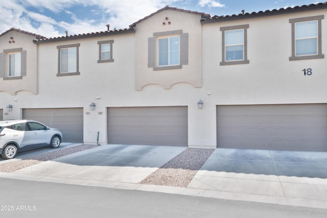 155 N Lakeview Blvd Unit 268, Chandler, AZ 85225 - view of front of house featuring a garage, stucco siding, driveway, and a tiled roof