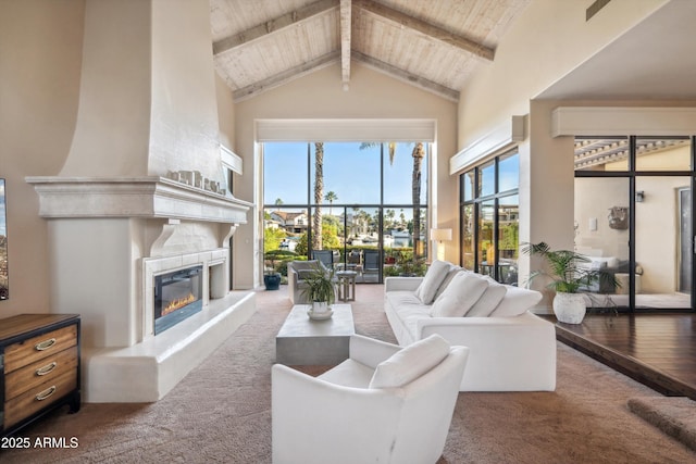 carpeted living room featuring a tile fireplace, beam ceiling, high vaulted ceiling, and wooden ceiling