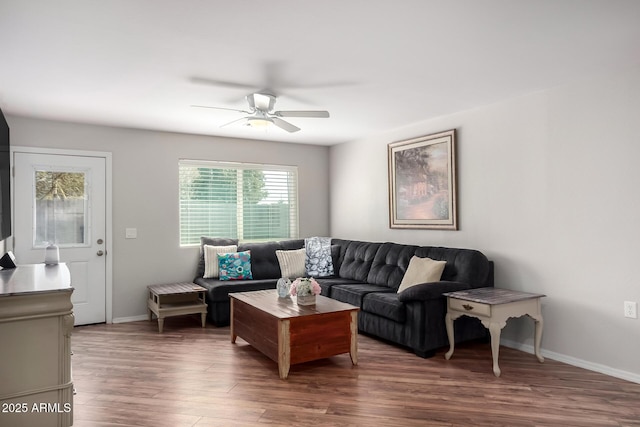 living area with dark wood-style floors, ceiling fan, and baseboards