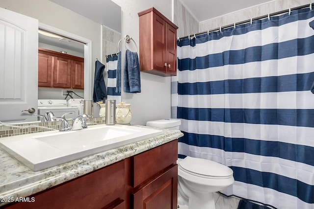 full bath with toilet, separate washer and dryer, and vanity