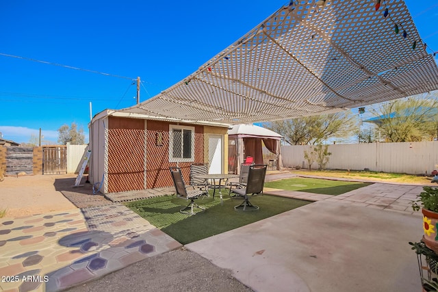 back of house with a gazebo, a fenced backyard, a tiled roof, and a patio