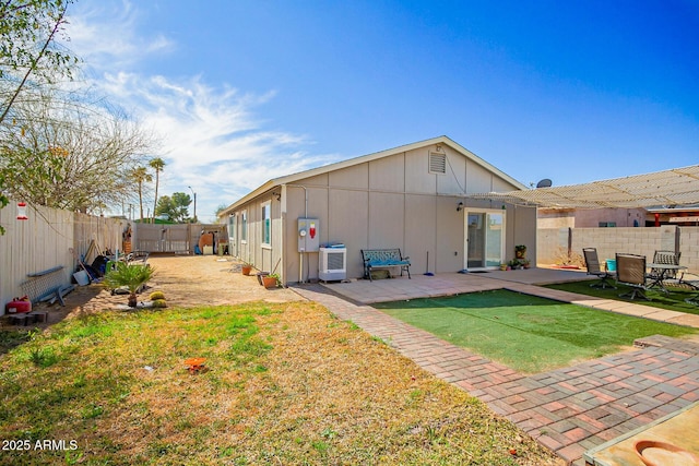 back of house featuring a yard, a fenced backyard, and a patio