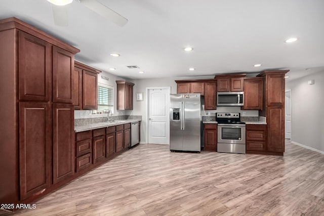 kitchen featuring light wood finished floors, visible vents, stainless steel appliances, and a sink