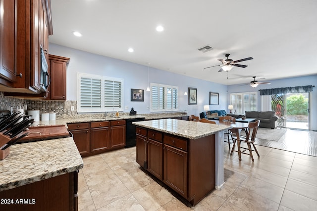 kitchen featuring a center island, black dishwasher, tasteful backsplash, visible vents, and a sink