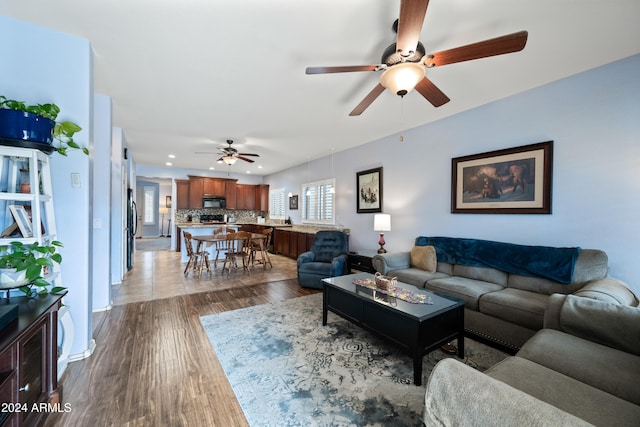 living area with dark wood-style floors, baseboards, and recessed lighting