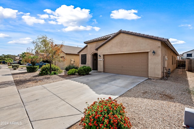 mediterranean / spanish home with concrete driveway, an attached garage, a tiled roof, and stucco siding